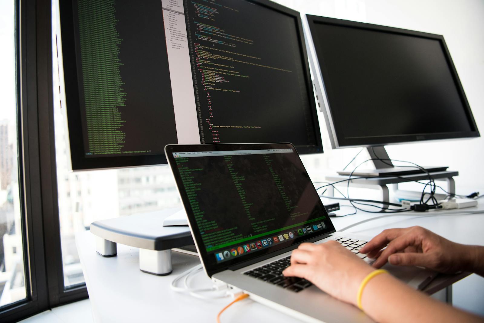 Analyst working across several monitors in an office