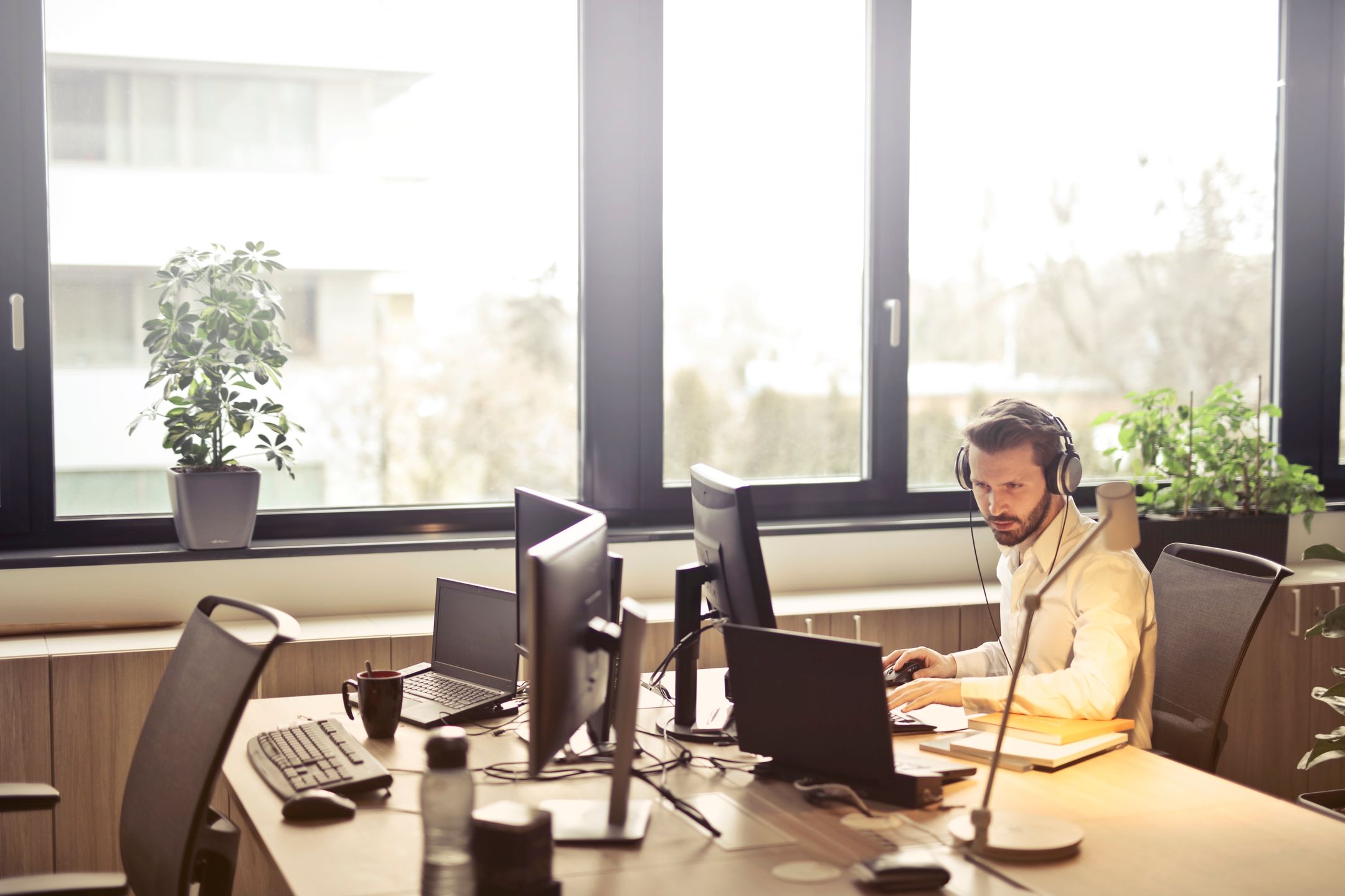 IT support technician with a headset working at their monitors in a bright office